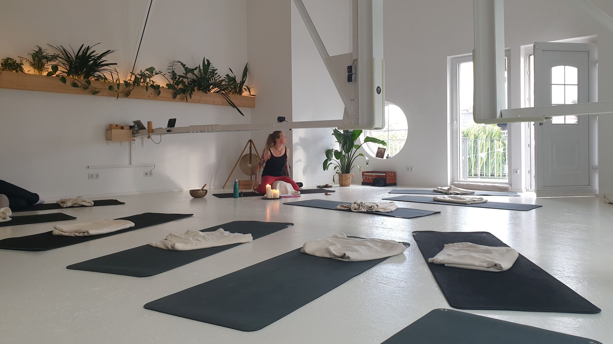 Das Yoga Labor in Berlin mit vorbereiteten Matten, Nicole im Hintergrund